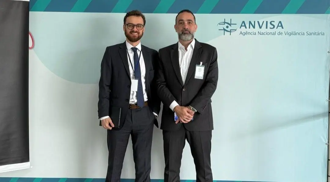 Rafael Arcuri, com outro participante, diante do painel da Anvisa